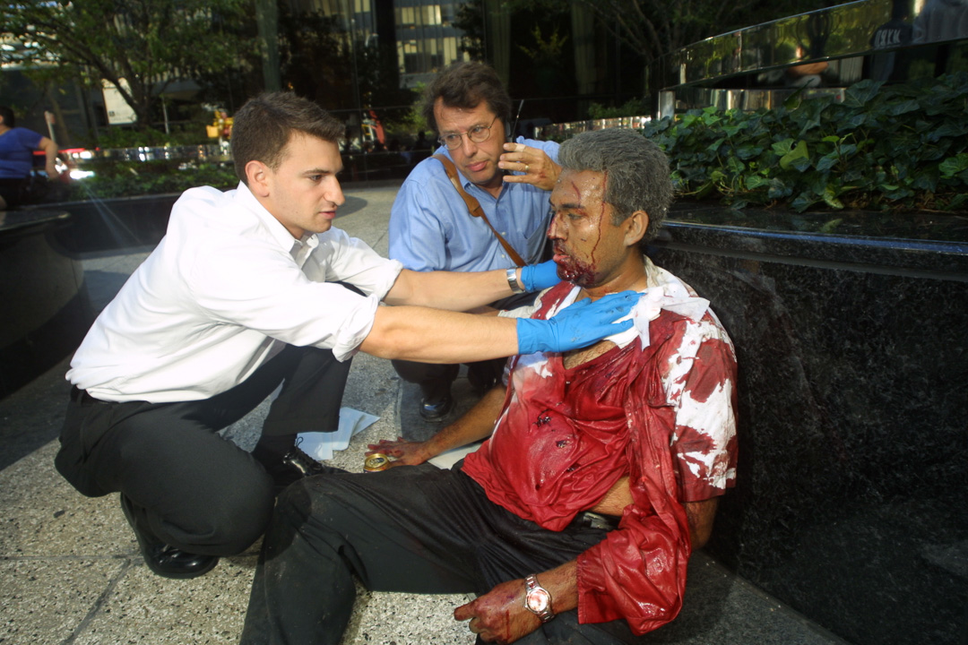 Two volunteers aid an injured man at the WTC