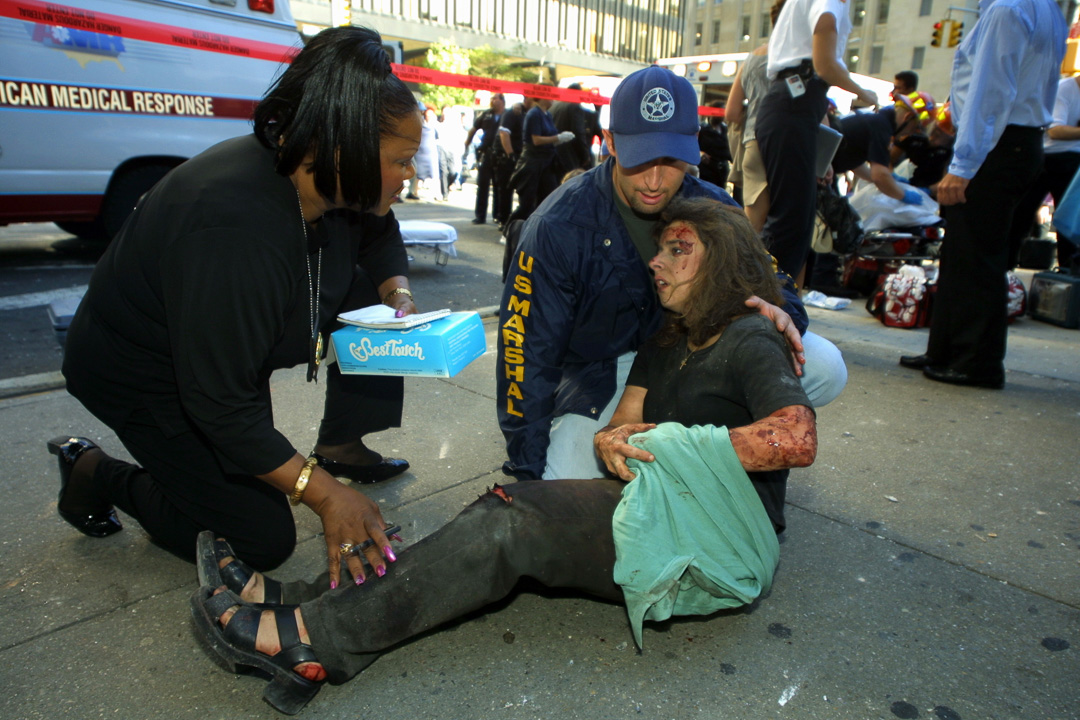 Volunteers help an injured woman at the WTC
